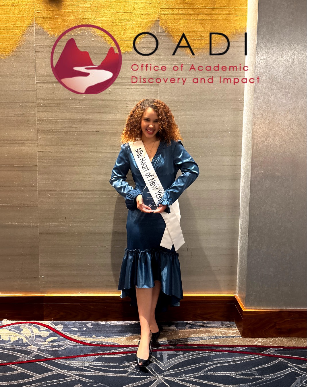 Mary Bellakbira in a blue dress wearing a Miss Heart of New York sash